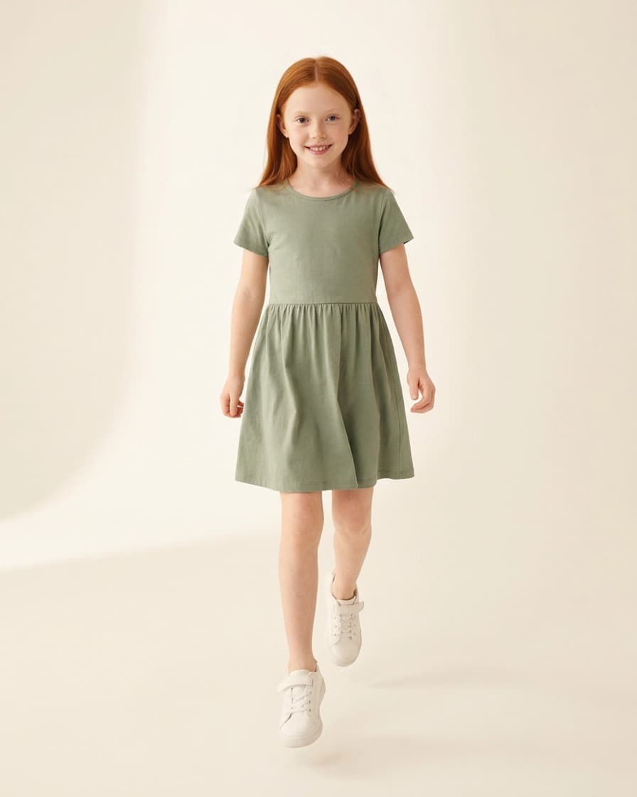 Modelo sintética infantil caminhando com vestido verde e tênis branco